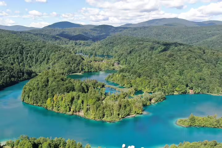 Wide view of Plitvice Lakes National Park forest and waterfall over turquoise lake, Croatia entry ticket