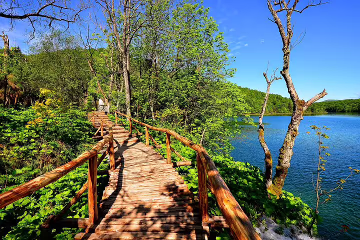 Wooden boardwalk along a turquoise lake in Plitvice Lakes National Park, Croatia admission ticket tour