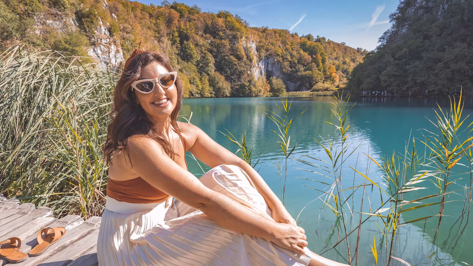 Traveler relaxing by a turquoise Plitvice lake on a hidden gems day trip from Zagreb, Croatia
