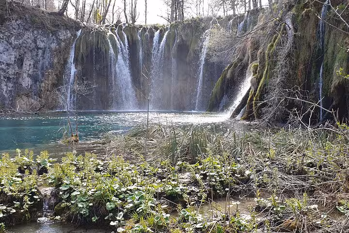 Plitvice Lakes waterfall spilling into turquoise pool on private day trip from Zagreb to Plitvice and Rastoke