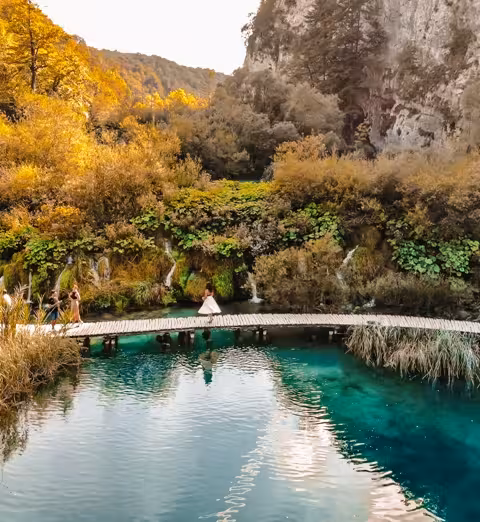 Wooden footbridge over crystal-blue water at Plitvice Lakes National Park on a guided day trip from Split