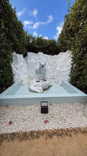 Stunning polar bear sculpture in a lush garden setting, perfect for art enthusiasts on a Sculpture & Art Tour.