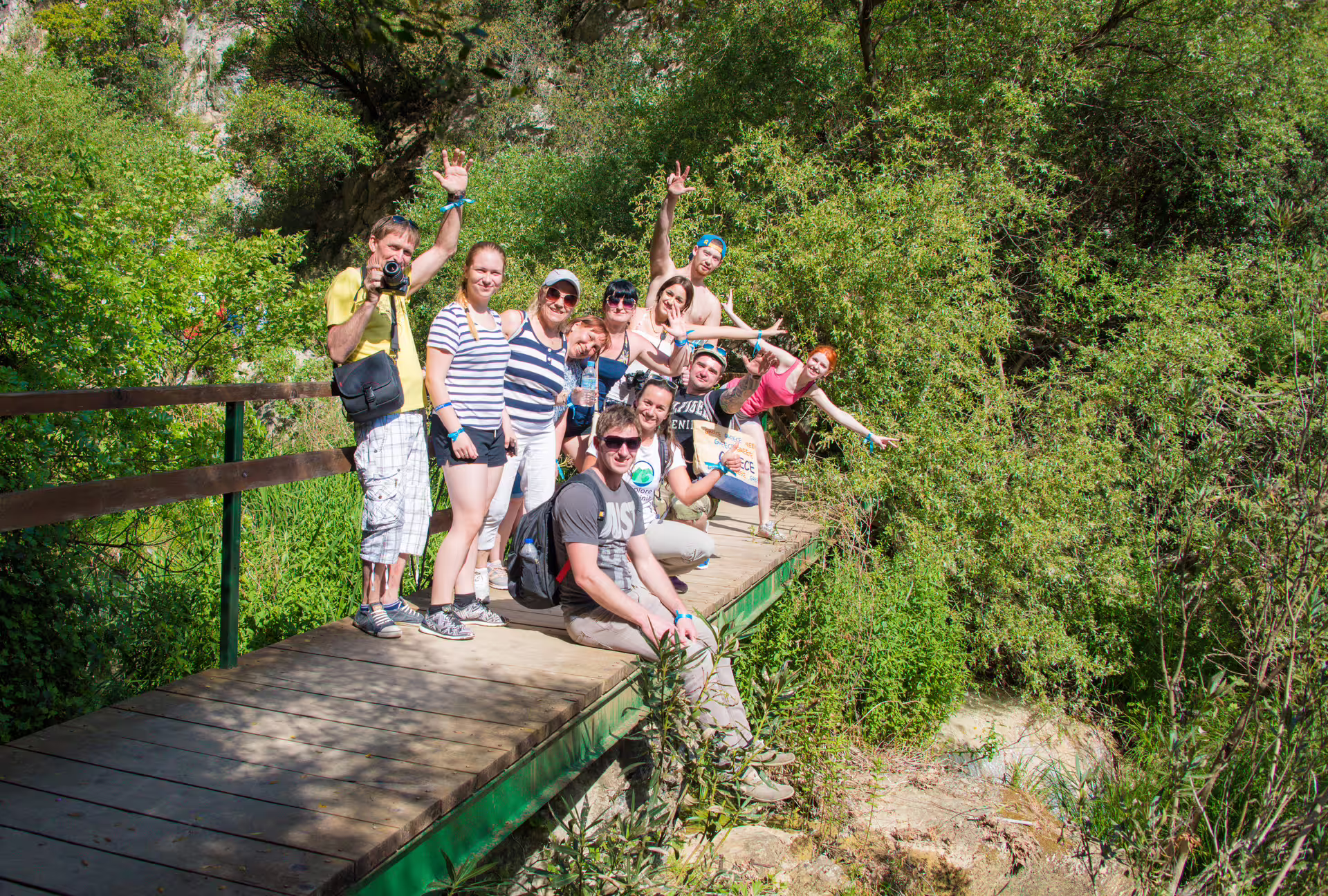 Group photo on a wooden bridge during the Polylimnio Waterfalls hiking tour in Messinia near Kalamata, Greece
