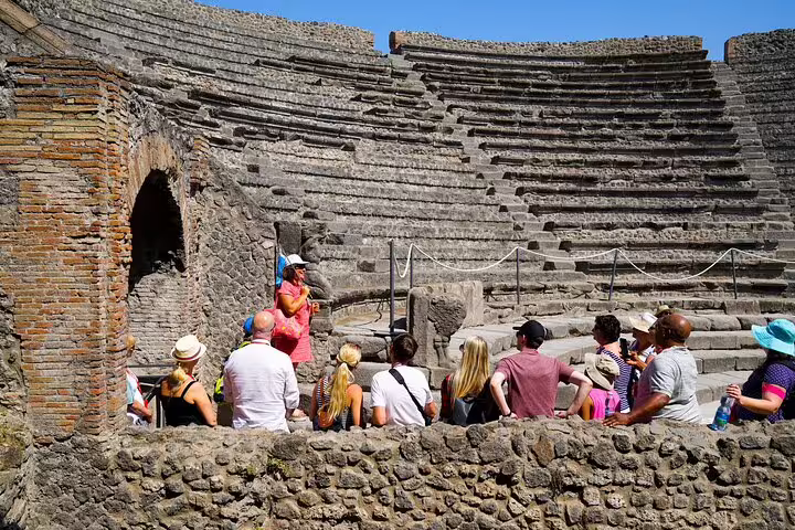 A guided group explores the ancient amphitheater at Pompeii Ruins, offering a glimpse into Roman history.