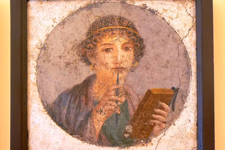 Ancient fresco of a woman holding a stylus and wax tablet, found in the ruins of Pompeii, Italy.