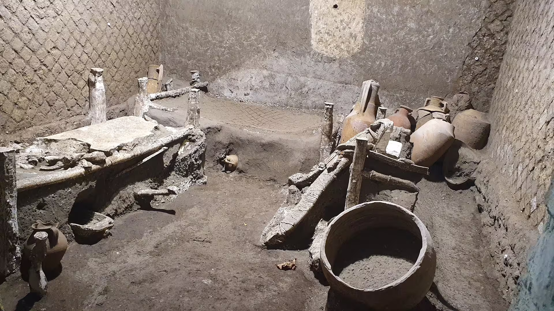 Preserved Pompeii room with ancient beds and amphorae, key stop on Naples group tour with wine tasting