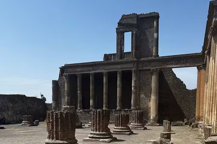 Ruins of a grand ancient building with columns in Pompeii, showcasing historical architecture.