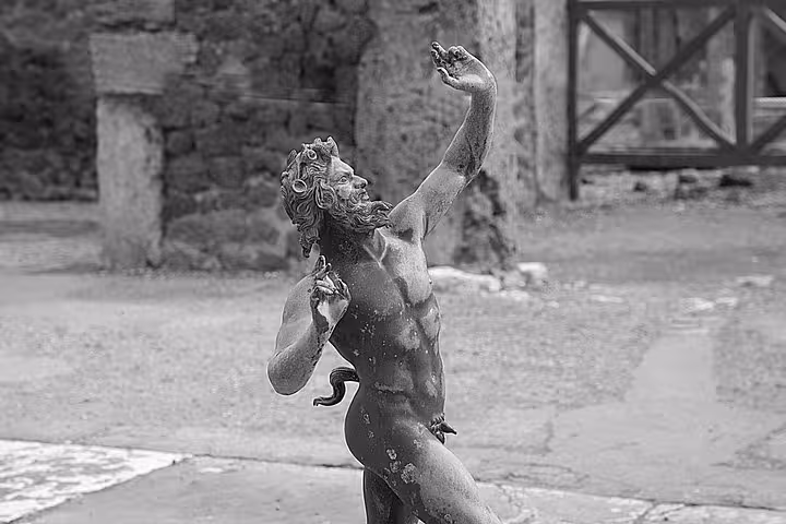 Ancient statue of a dancing figure at Pompeii, showcasing rich historical artistry on the Pompeii and Vesuvius tour.