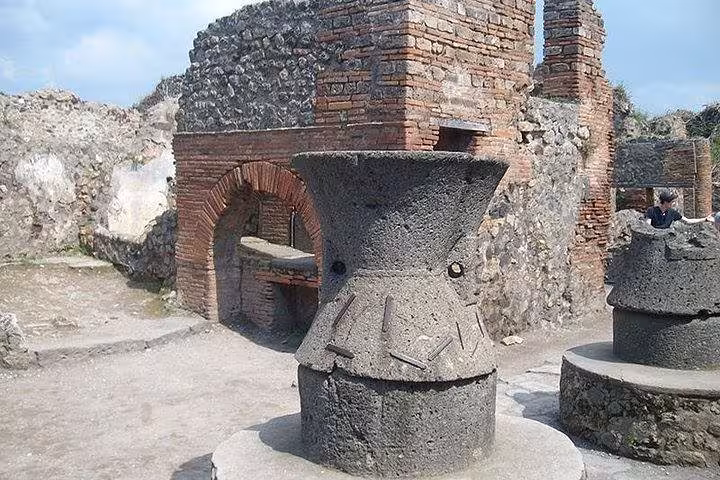 Ancient stone mill in the ruins of Pompeii showcasing historic architecture on the Pompeii & Mount Vesuvius tour.