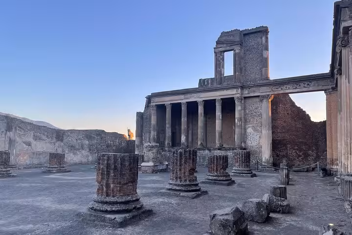Ancient temple ruins with columns and stone structures in Pompeii during a skip-the-line private tour.