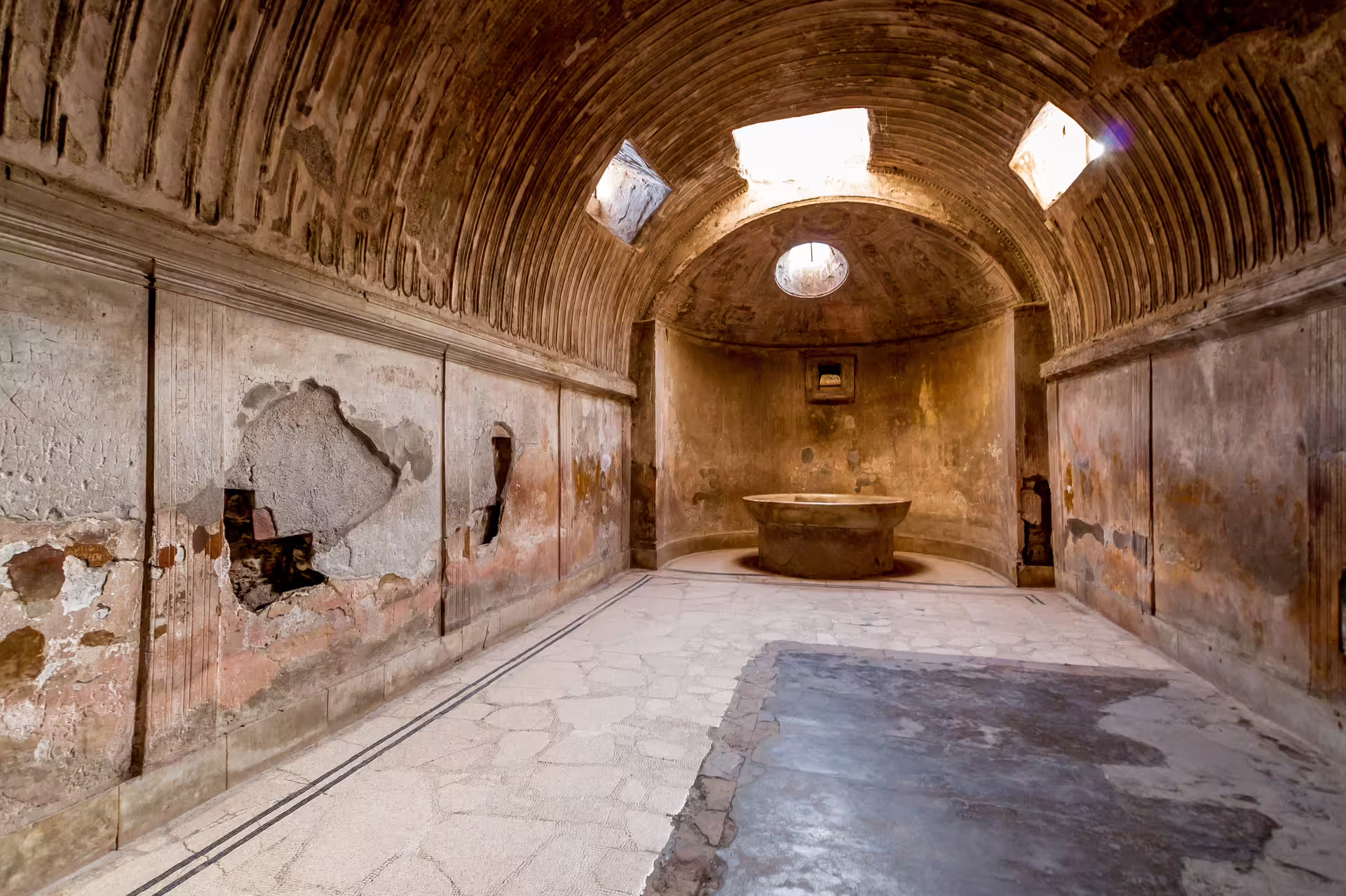 Ancient Pompeii bathhouse interior with barrel-vaulted ceiling, highlight of Pompeii and Vesuvius tour from Naples