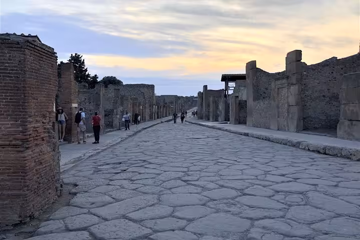 Evening view of a cobblestone street in Pompeii with ancient ruins, capturing the timeless ambiance of the archaeological site.