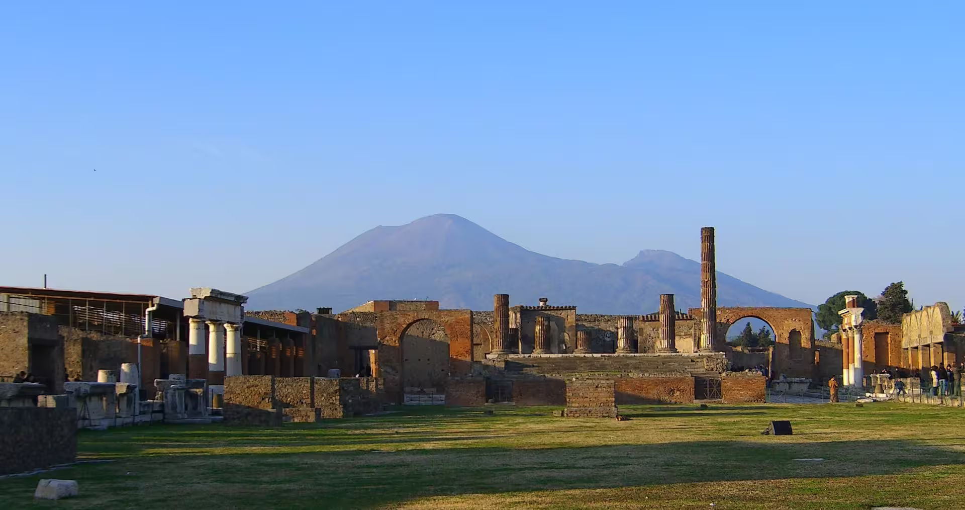 Panoramic view of Pompeii forum ruins with Mount Vesuvius in the background on a full-day guided tour from Naples