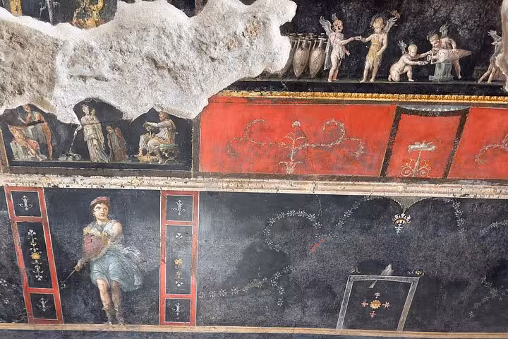 Intricate fresco in Pompeii depicting ancient Roman figures and decorations, ideal for cultural tours from Amalfi Coast.