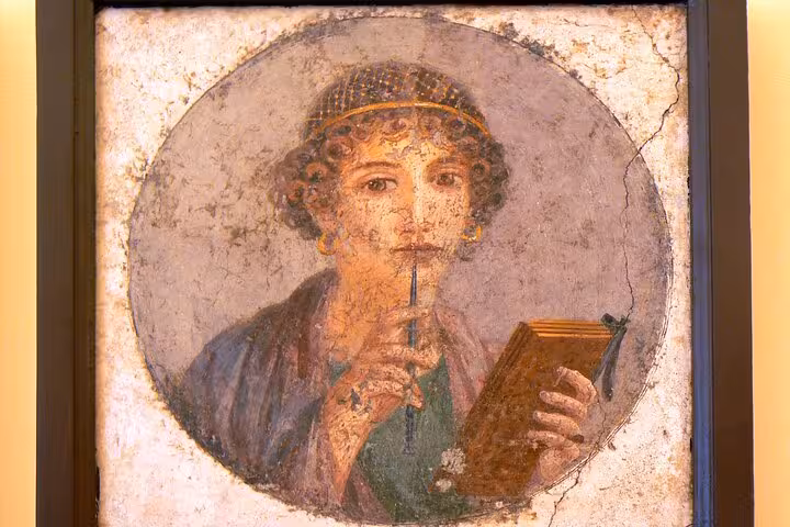 Fresco of a woman with a stylus and tablet in Pompeii, showcasing ancient Roman art for cultural tours from Naples.