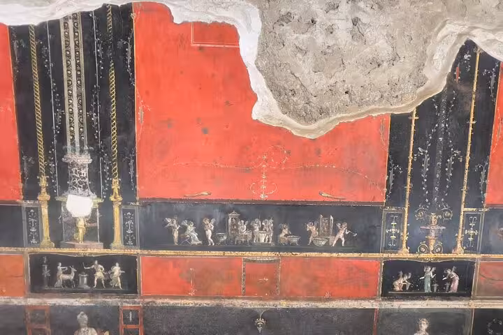 Detailed frescoes in Pompeii with rich colors and mythological scenes, ideal for a small group Vesuvius tour.