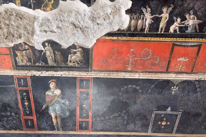 Vibrant frescoes in Pompeii depict ancient Roman life, perfect for a Vesuvius and wine tasting tour from the Amalfi Coast.