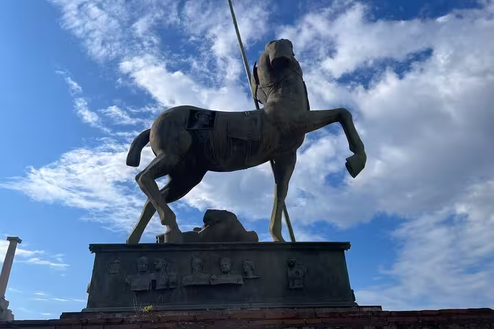 Impressive horse statue under a blue sky at the Pompeii archaeological site, perfect for Amalfi Coast tours.