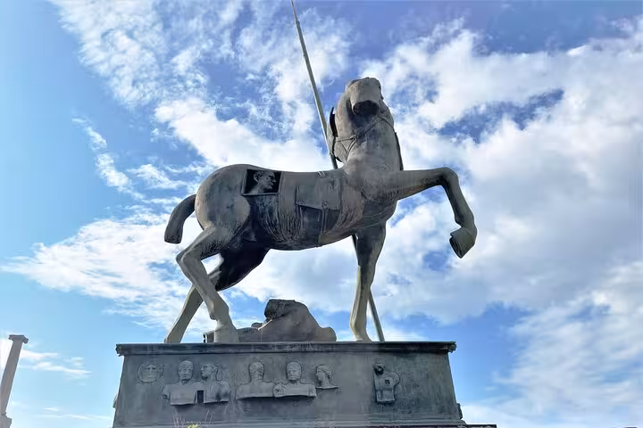 Statue of a horse at Pompeii against a blue sky, symbolizing historic allure for guided tours from Sorrento Coast.