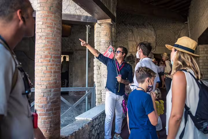 Guide explaining Pompeii's indoor ruins to an attentive group on a Skip The Line tour from Sorrento.