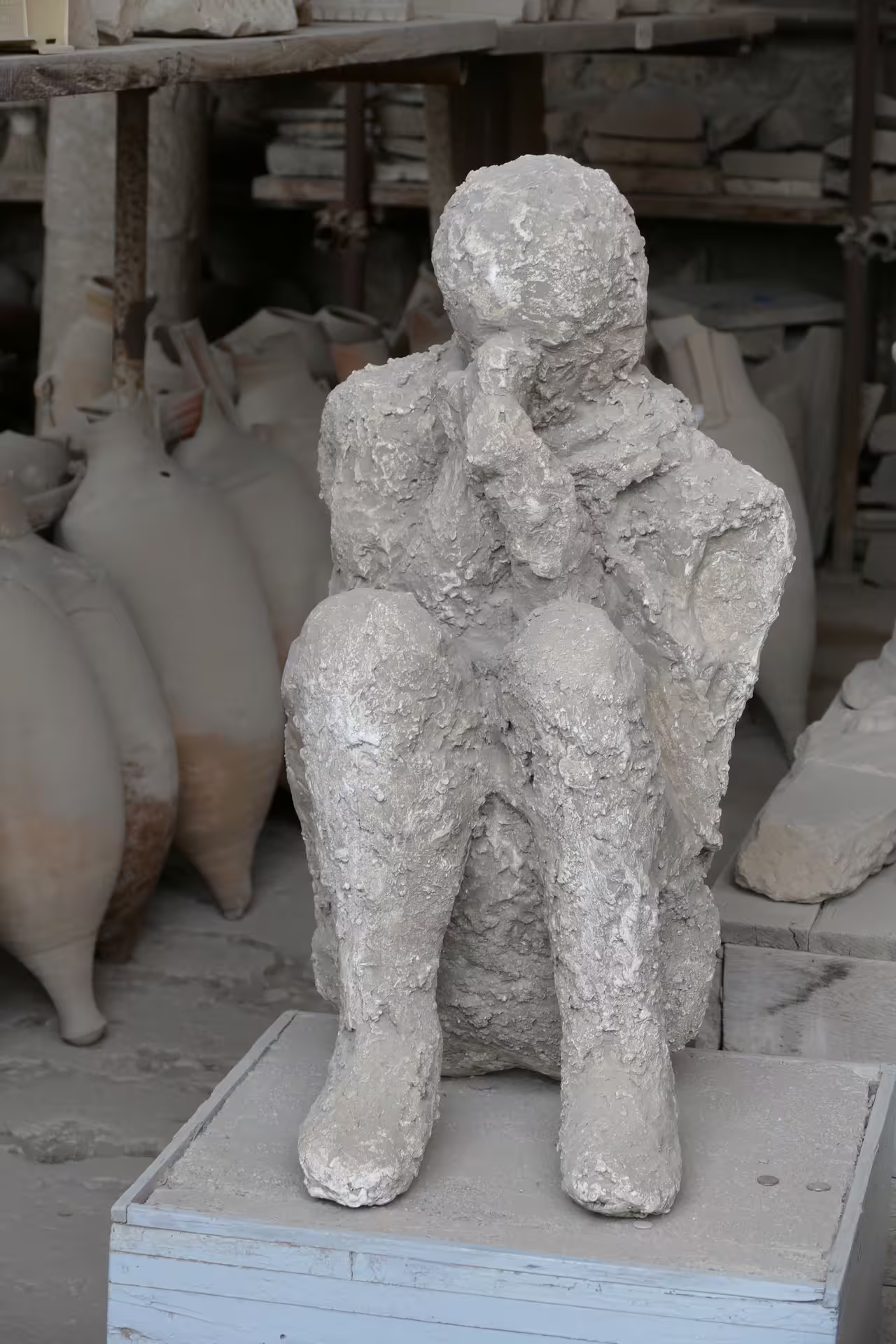 Pompeii plaster cast of a seated victim in the ruins, highlight of Pompeii and Herculaneum group tour from Naples