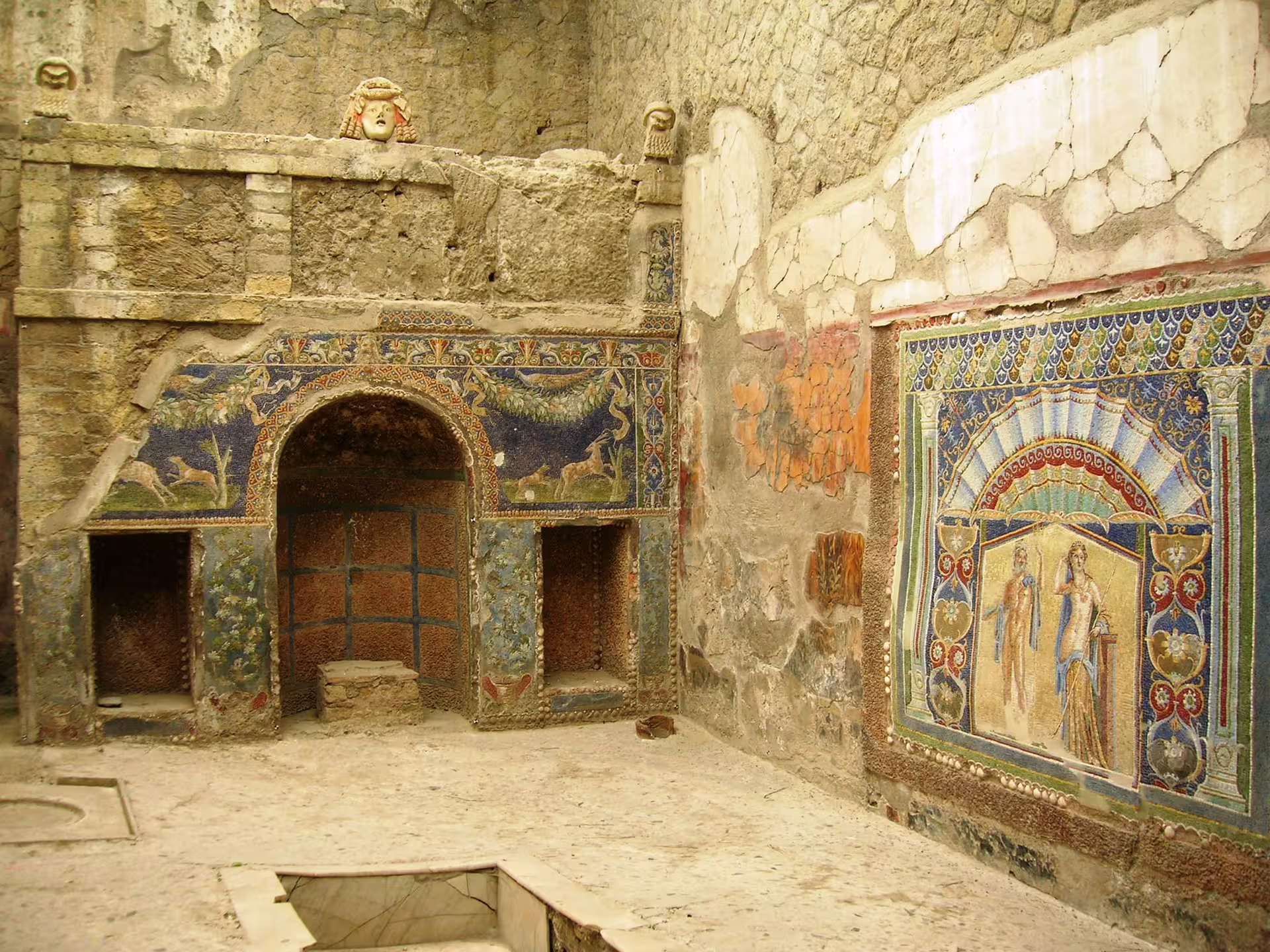 Pompeii ruins interior with vivid Roman frescoes and mosaic wall, highlight of half day group tour from Naples