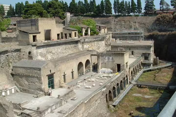 Ancient excavated ruins near Pompeii on a private tour, showcasing preserved Roman arches, villas and coastal cliffs
