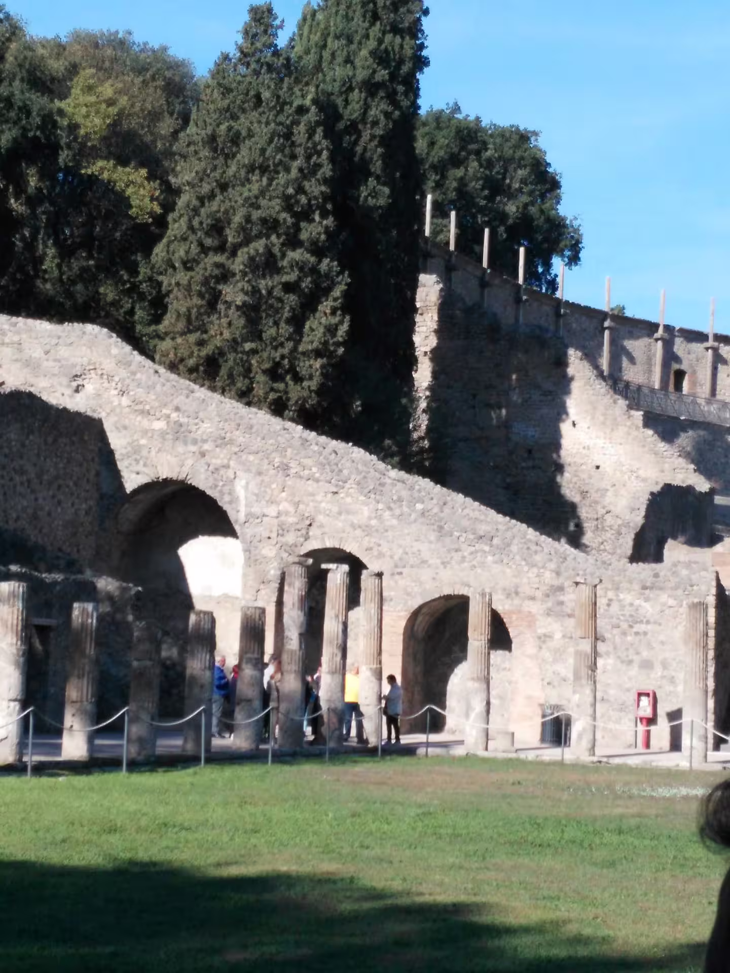 Pompeii ruins with arches and columns in the archaeological park, stop on Pompeii and Herculaneum group tour from Naples