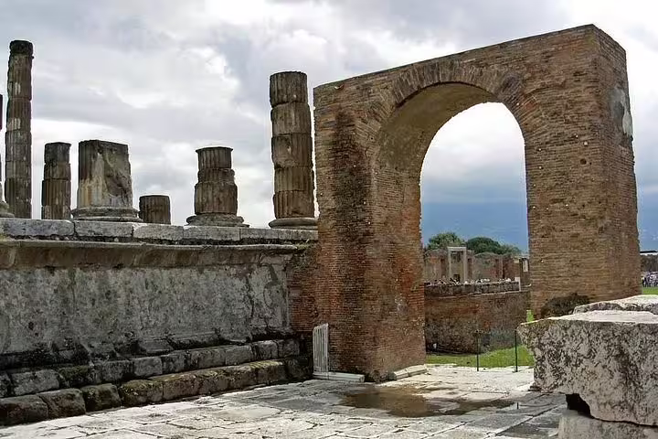 Ruined archway and temple columns in Pompeii archaeological park featured on a private Mt Vesuvius and winery day tour