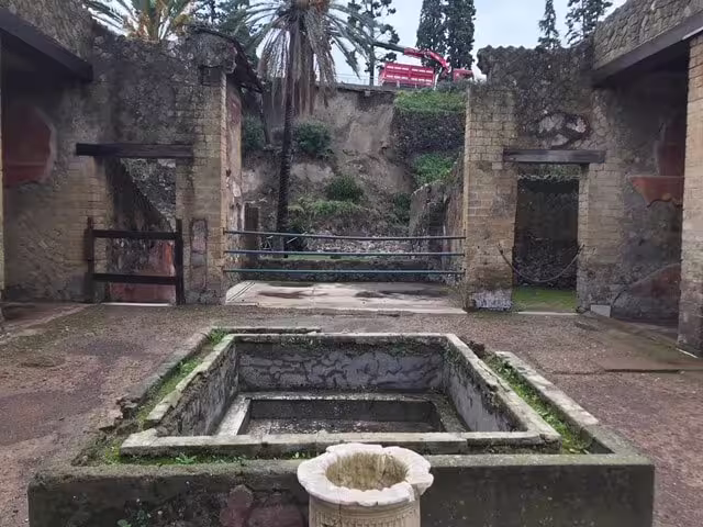 Pompeii ruins courtyard with ancient cistern and stone walls on low cost day trip from Naples