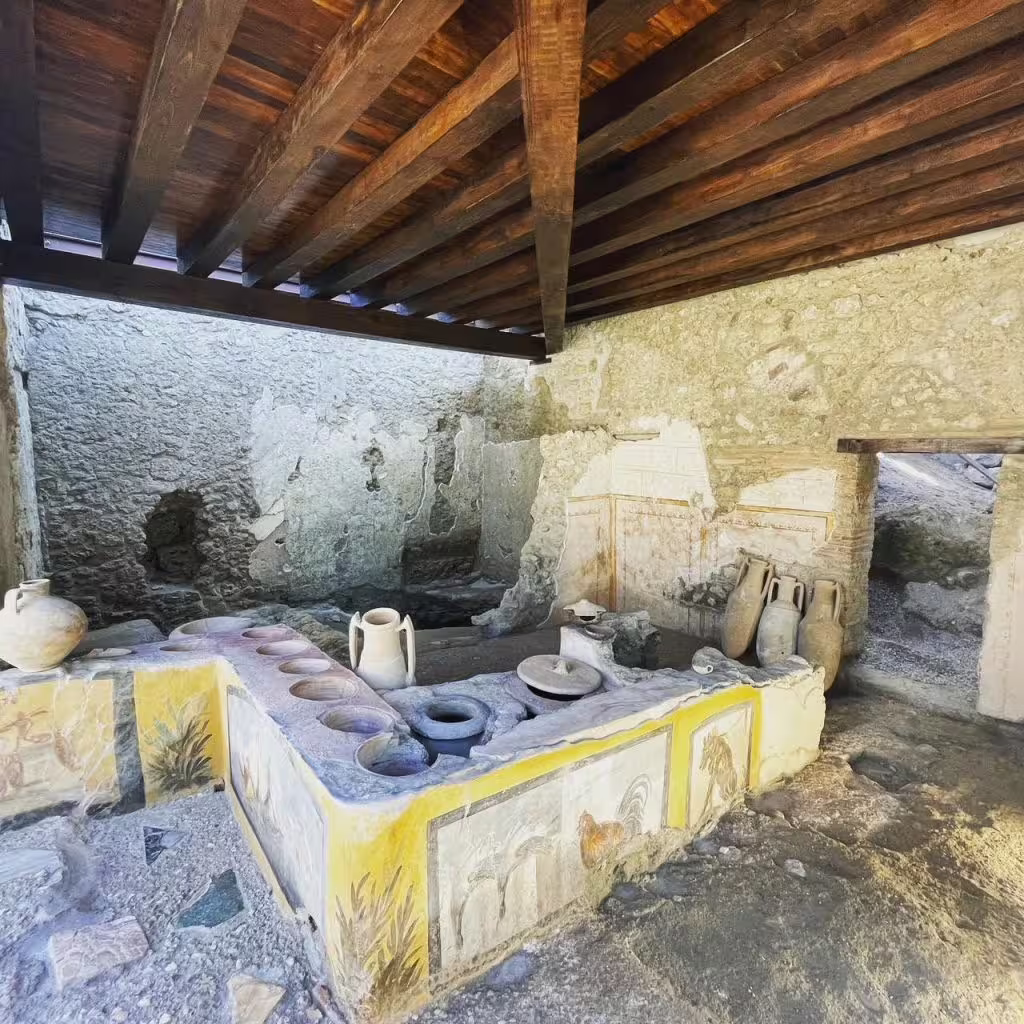 Pompeii ruins kitchen with ancient jars and frescoes on Naples group tour with Vesuvius wine tasting