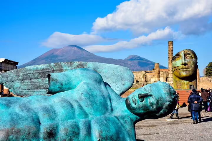 Pompeii ruins with modern sculpture and Mount Vesuvius backdrop, private Naples tour to Pompeii and Herculaneum