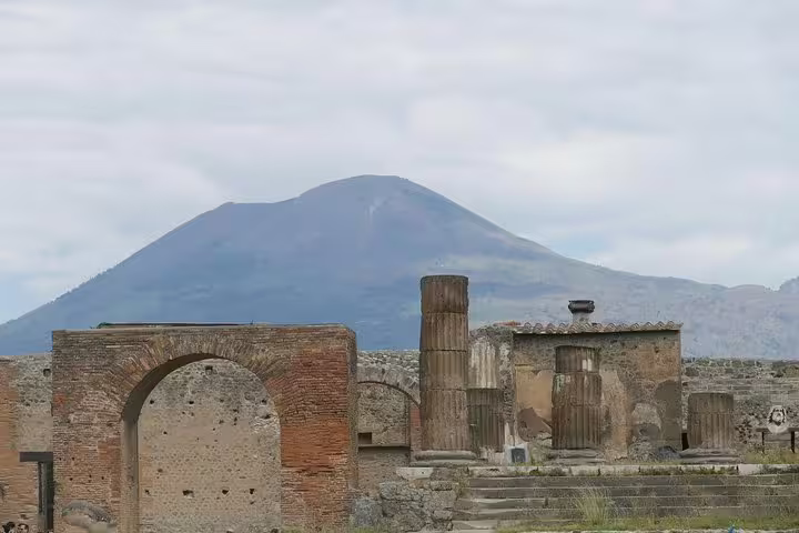 Pompeii ruins with Mount Vesuvius backdrop, key stop on Pompeii & Naples group tour from Naples