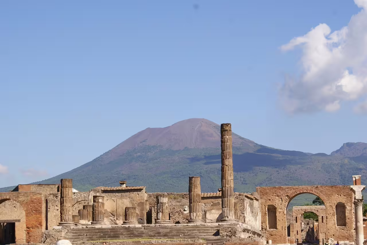 Panoramic view of Pompeii ruins with Mount Vesuvius in the background, included in a full-day guided tour itinerary