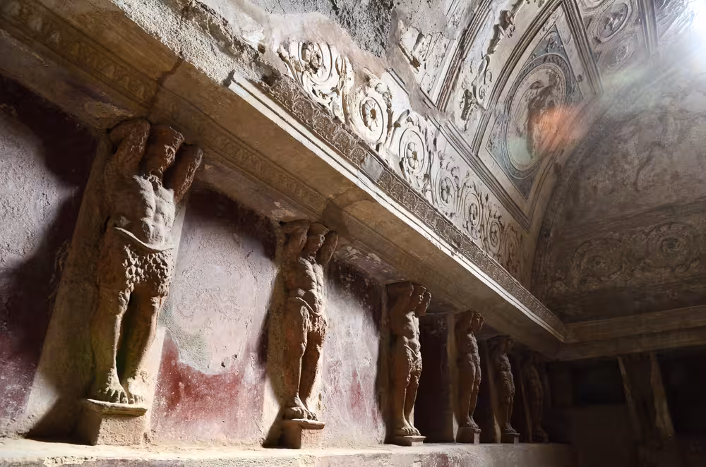 Intricate stone carvings and pillars at Pompeii site, highlighting ancient architecture on Naples tour.