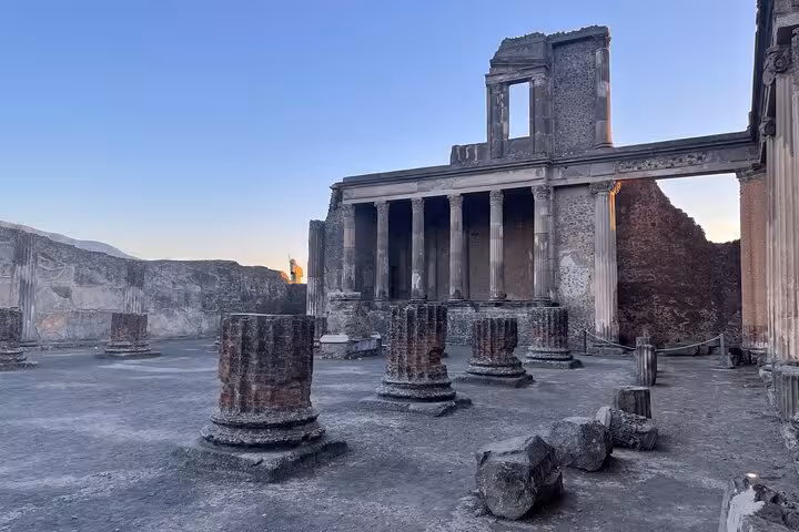 View the majestic ruins of a temple in Pompeii at sunset, part of the Amalfi Coast guided tour with skip-the-line access.