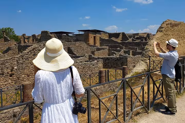 Tourists exploring ancient ruins of Pompeii on a sunny day, capturing the historical essence of the site.