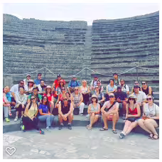 Group photo inside Pompeii amphitheatre on a guided Pompeii and Mount Vesuvius tour from Naples