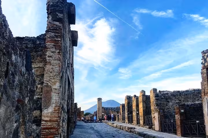 Explore the ancient streets of Pompeii with Mount Vesuvius in the background on a small group tour from Sorrento.