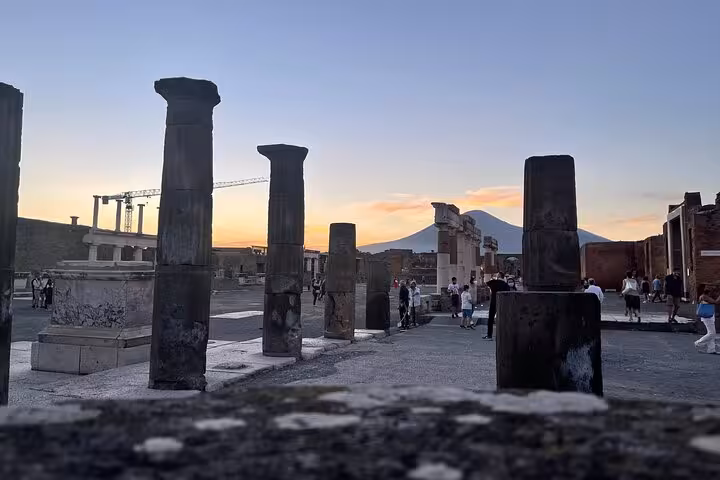 Sunset view of Pompeii ruins with Mount Vesuvius, perfect for historical tours and wine tasting from the Amalfi Coast.