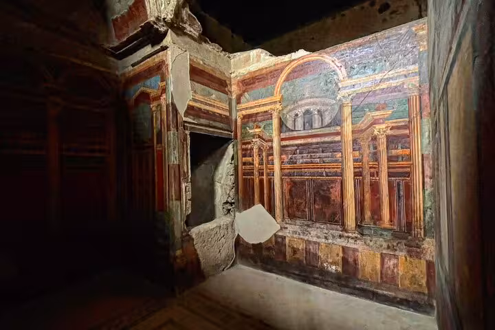 Vibrant frescoes in a Pompeii villa, highlighting ancient Roman art on a guided tour with skip-the-line access.