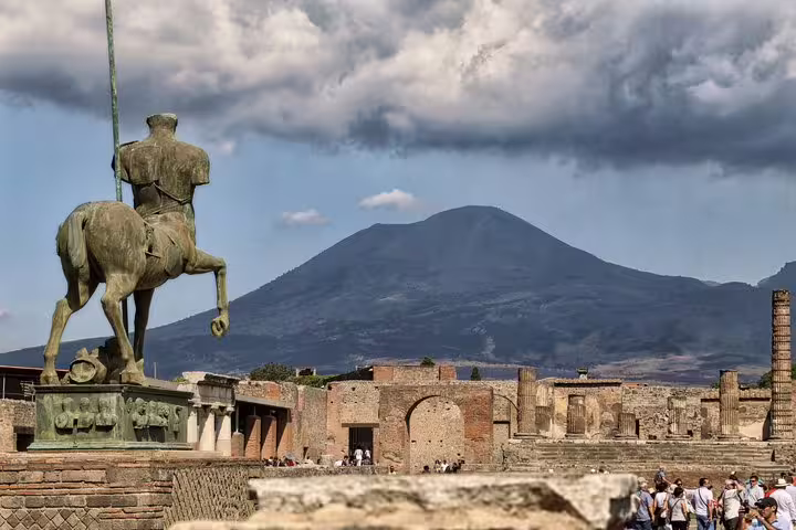Pompeii ruins VIP small-group tour from Naples, statue and ancient forum with Mount Vesuvius backdrop