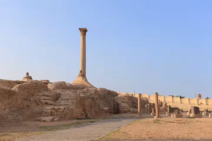 Pompeys Pillar rising over Serapeum ruins in Alexandria, Egypt, a must-see stop on city sightseeing tour