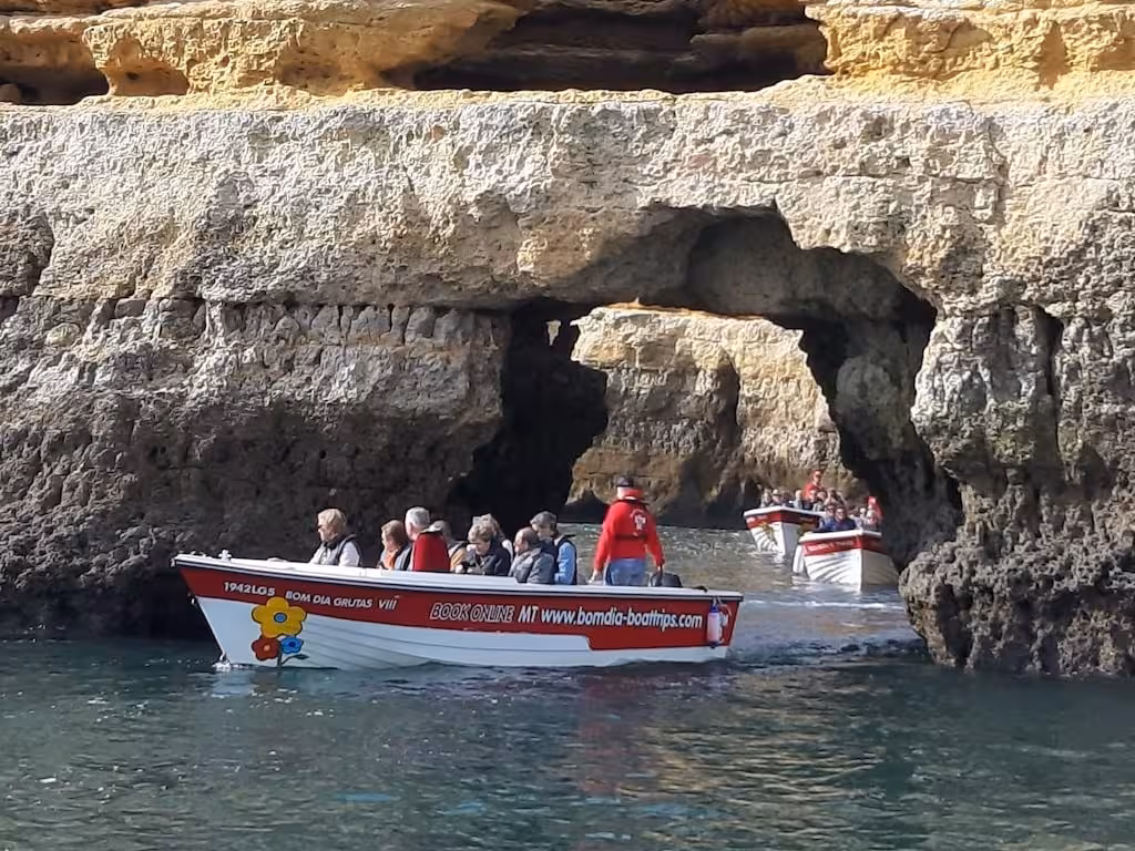 Guided boats glide through natural rock arches and sea caves on a scenic Ponta da Piedade grotto tour along the Algarve coast