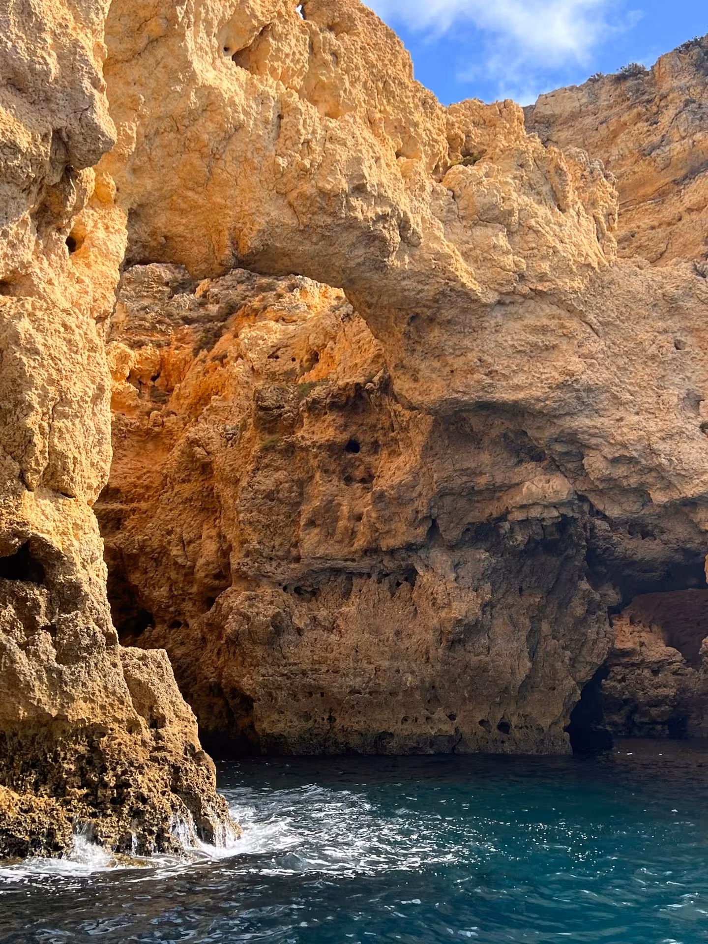 Close-up of rugged limestone arch and turquoise water inside the Ponta da Piedade grottoes on a Lagos Algarve boat tour