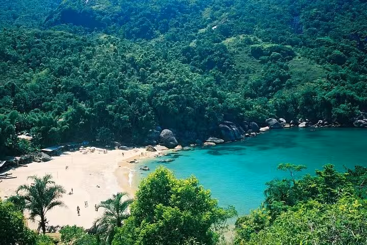 Stunning aerial view of Ponta Negra's turquoise bay and sandy beach surrounded by lush green rainforest.