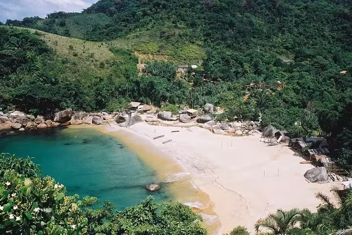 Scenic aerial view of Ponta Negra's pristine beach and emerald waters bordered by dense tropical vegetation.