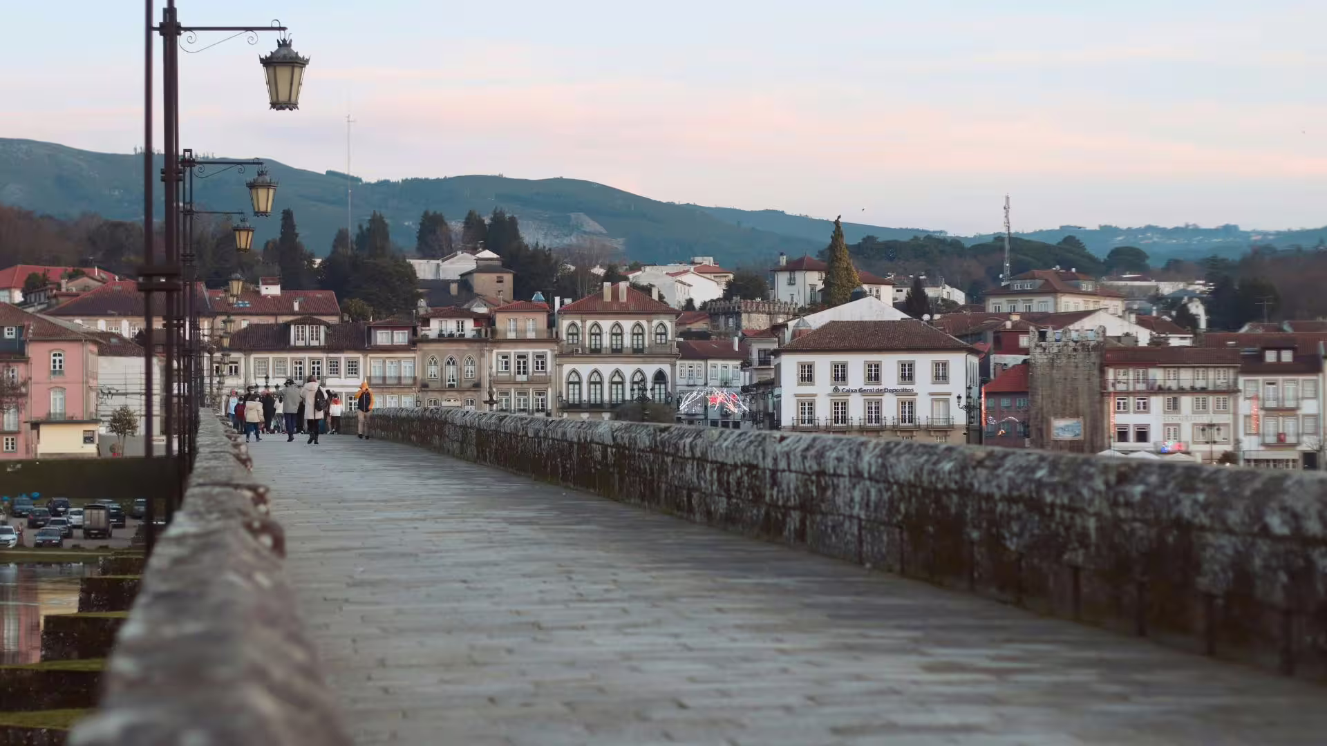 Scenic view of Ponte de Lima bridge with historic architecture and mountains in the Minho Region tour.