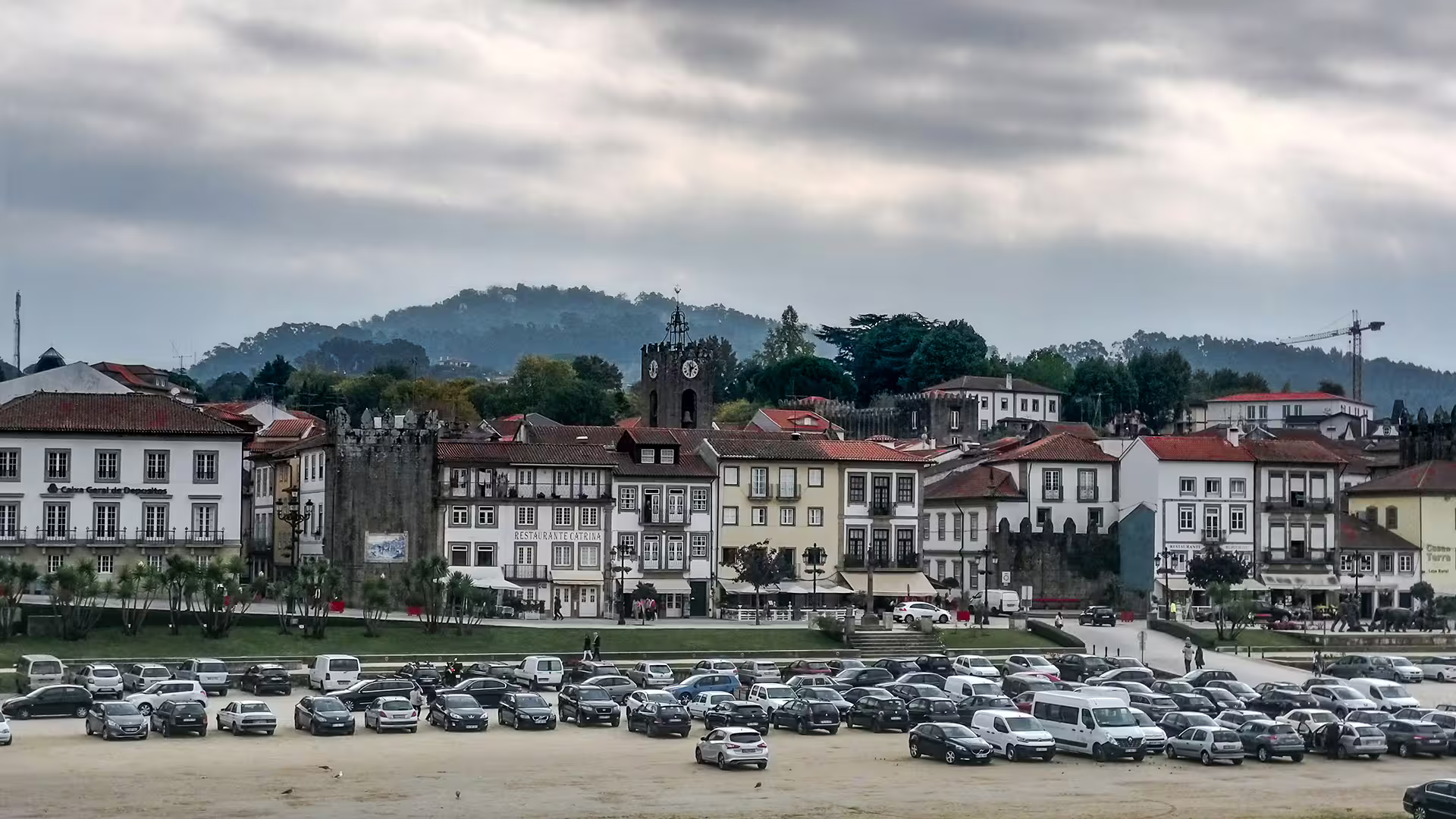 Scenic view of Ponte de Lima with historic architecture and parked cars, perfect for exploring the Vinho Verde wine region.