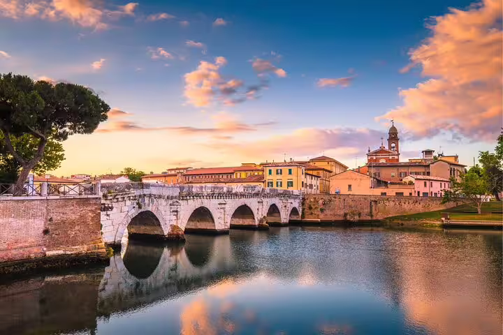 Ponte di Tiberio over the Marecchia River at sunset, a key stop on the Rimini self-guided scavenger hunt tour